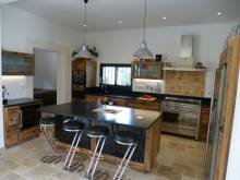 Cuisine en vieux chêne avec des plans de travail en granit Zimbabwe à Chateaurenard à coté d'Avignon avec piano de cuisson inox et cave à vin le Chai fabriquée par ABD Select cuisiniste à Barbentane.